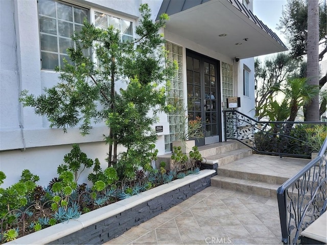 view of exterior entry featuring a patio area and stucco siding