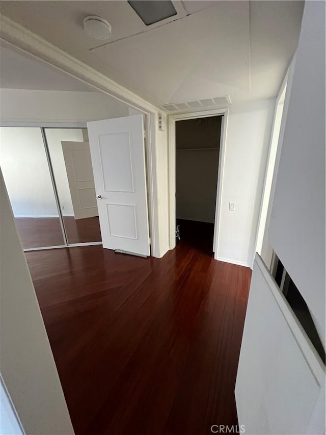 hall featuring vaulted ceiling and wood finished floors