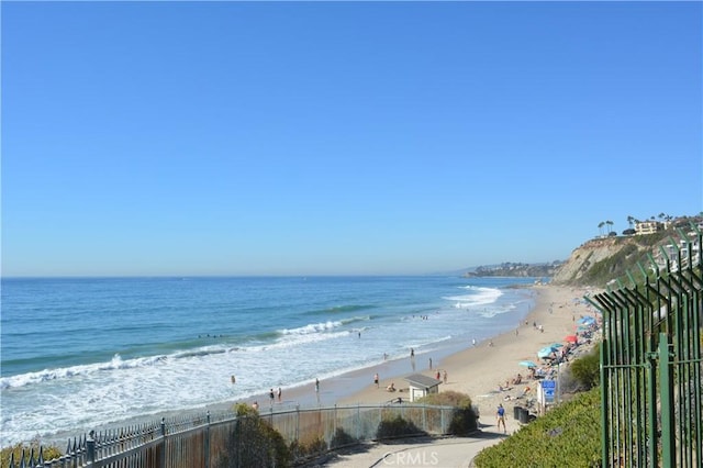 view of water feature with a view of the beach and fence