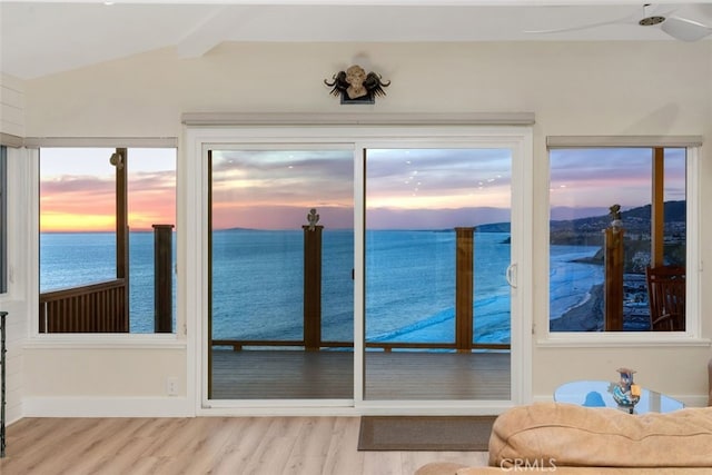 sunroom / solarium with a water view and beam ceiling