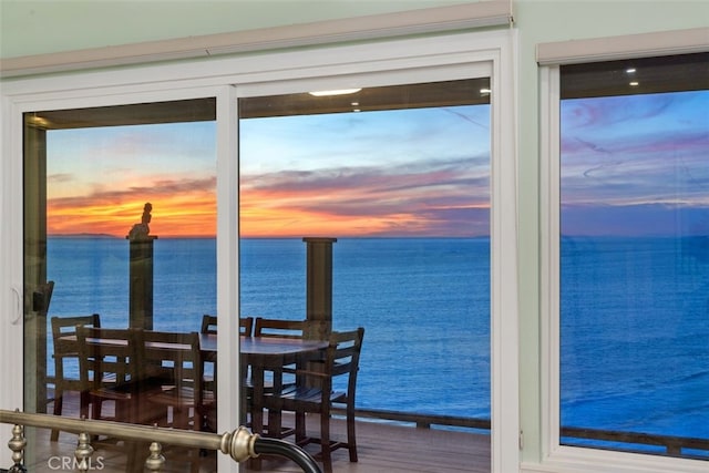 dining space with wood finished floors and a water view
