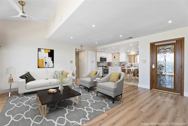 living room featuring recessed lighting, baseboards, light wood finished floors, visible vents, and a ceiling fan