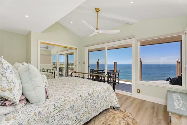 bedroom with a water view, light wood-style flooring, access to outside, and vaulted ceiling