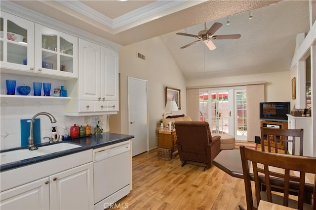 kitchen featuring light wood finished floors, white cabinets, open floor plan, white dishwasher, and a sink