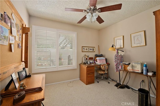 carpeted office space with ceiling fan, a textured ceiling, and baseboards