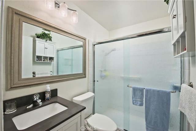 bathroom with a stall shower, vanity, and toilet