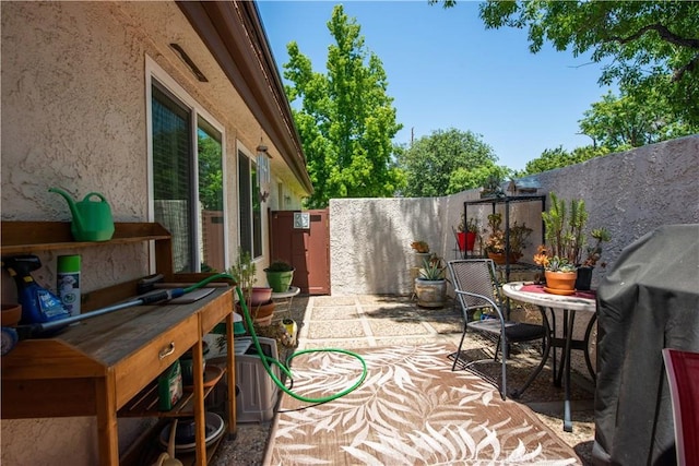 view of patio / terrace with a grill, fence, and outdoor dining space