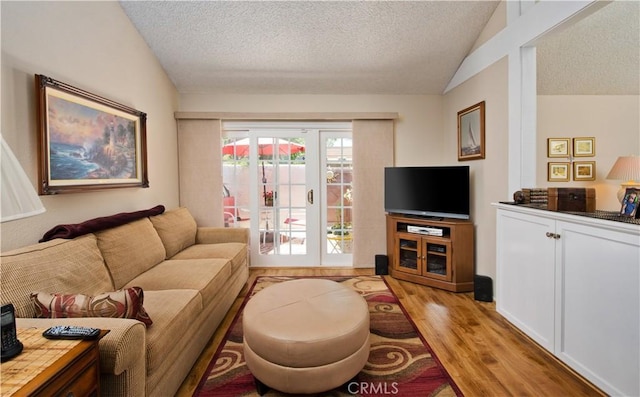 living area featuring light wood-style floors, lofted ceiling, and a textured ceiling