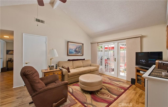 living room with visible vents, light wood-style flooring, beamed ceiling, a textured ceiling, and high vaulted ceiling