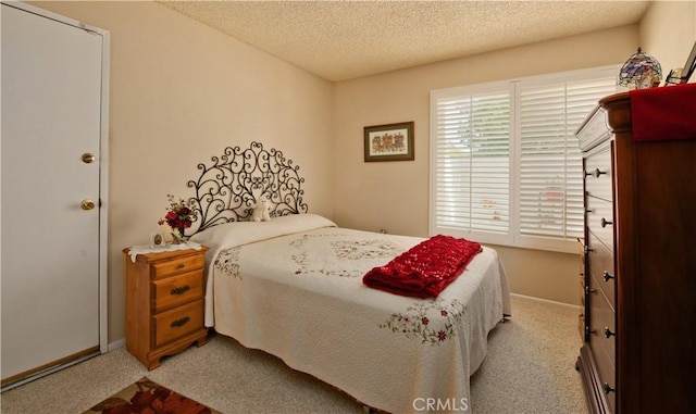 carpeted bedroom with baseboards and a textured ceiling