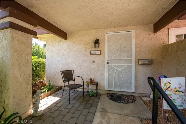 doorway to property featuring a patio and stucco siding