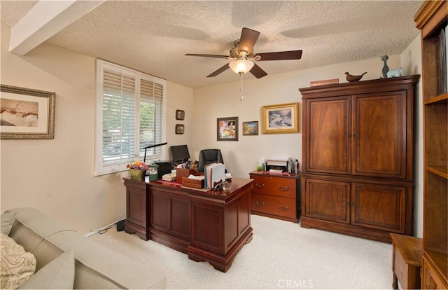 office featuring light carpet, ceiling fan, and a textured ceiling