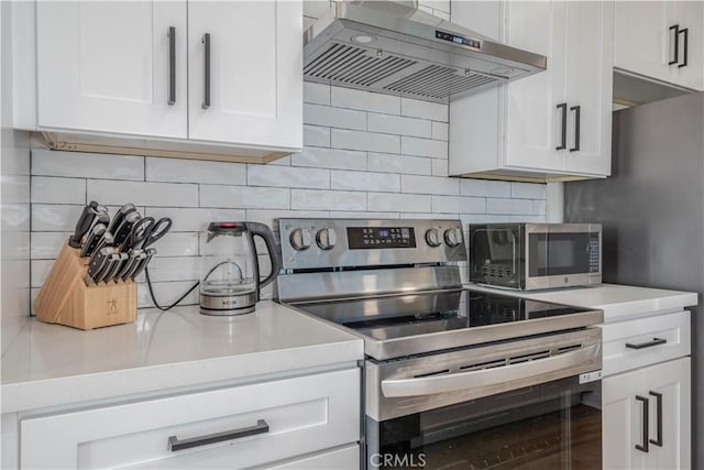 kitchen featuring light countertops, range hood, appliances with stainless steel finishes, and white cabinetry