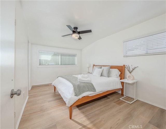 bedroom featuring ceiling fan, light wood-style flooring, and baseboards