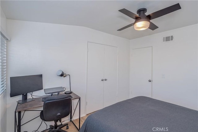 bedroom featuring wood finished floors, visible vents, a ceiling fan, and a closet