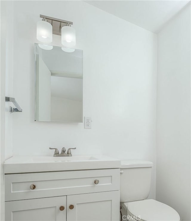 half bathroom featuring toilet and vanity