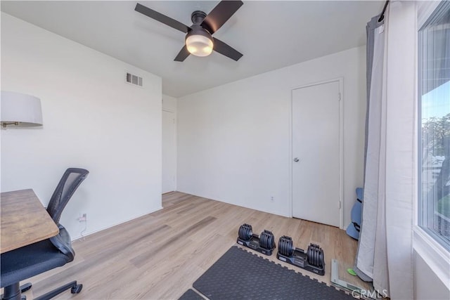 unfurnished office featuring visible vents, wood finished floors, and ceiling fan