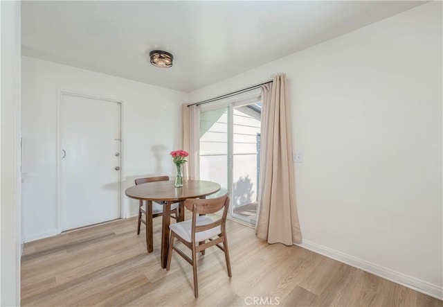 dining area with baseboards and light wood-type flooring