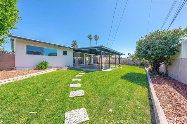 back of property with a patio, a fenced backyard, stucco siding, and a yard