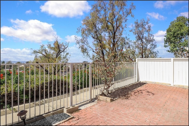 view of gate with a patio and fence