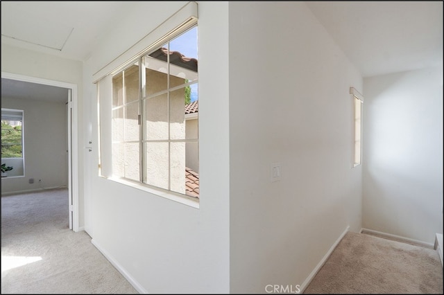 corridor featuring baseboards and carpet floors