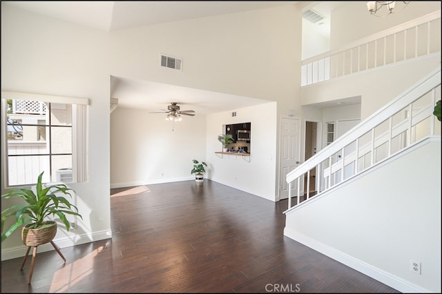 living room with wood finished floors, a ceiling fan, visible vents, high vaulted ceiling, and baseboards