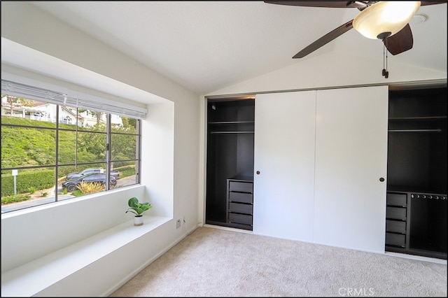 unfurnished bedroom with a closet, carpet flooring, a ceiling fan, and vaulted ceiling