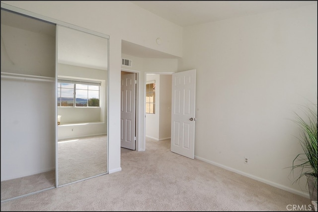 unfurnished bedroom with carpet, visible vents, a closet, and baseboards