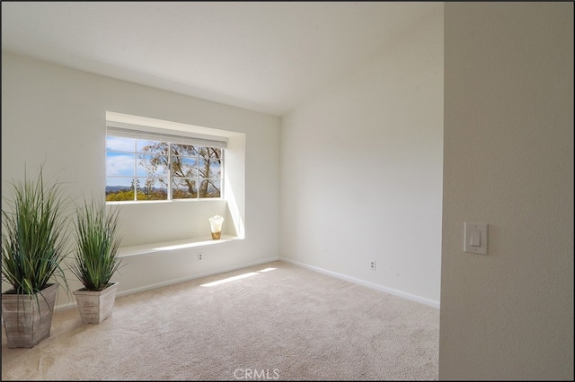 carpeted empty room featuring baseboards