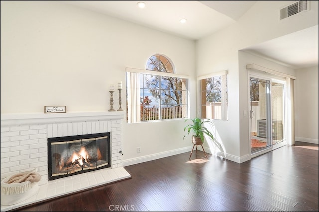 interior space featuring visible vents, wood finished floors, recessed lighting, a fireplace, and baseboards