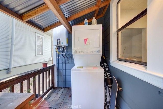 washroom with tankless water heater, stacked washing maching and dryer, and wood finished floors