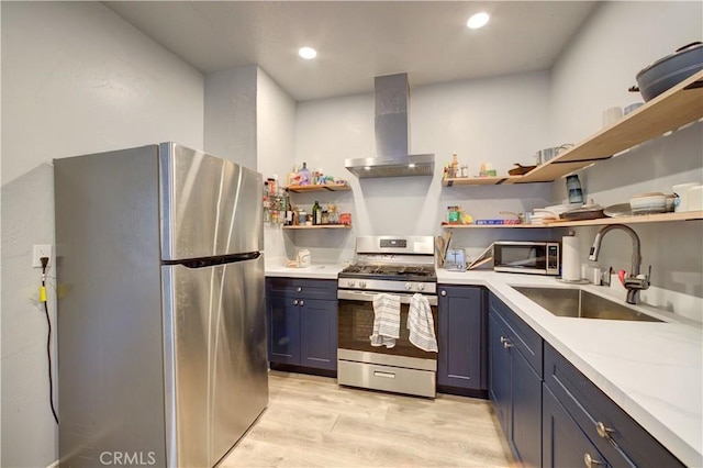 kitchen featuring open shelves, stainless steel appliances, light countertops, a sink, and wall chimney exhaust hood