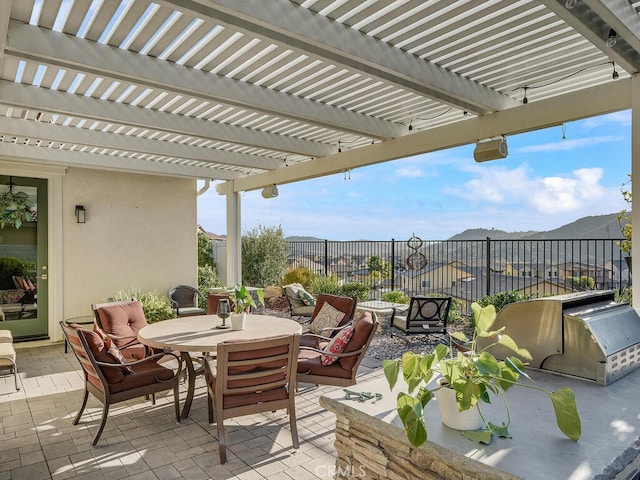 view of patio featuring an outdoor kitchen, area for grilling, fence, outdoor dining area, and a pergola