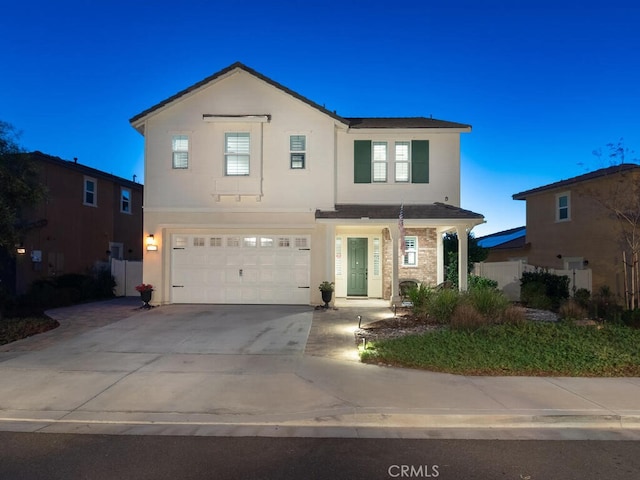 view of front of house with a garage, concrete driveway, and stucco siding