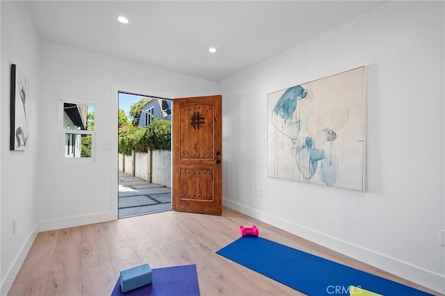 workout room featuring baseboards, wood finished floors, and recessed lighting