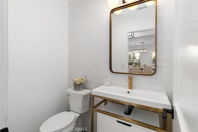 half bath featuring tile walls, toilet, and vanity