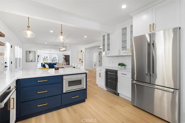 kitchen with wine cooler, light wood-style floors, white cabinets, high end fridge, and glass insert cabinets