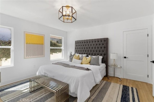 bedroom with a chandelier and wood finished floors