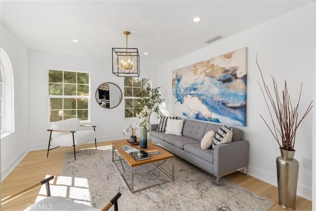 living room featuring recessed lighting, visible vents, baseboards, light wood finished floors, and an inviting chandelier