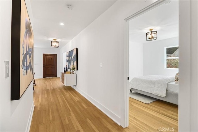 corridor featuring light wood-style floors, recessed lighting, and baseboards