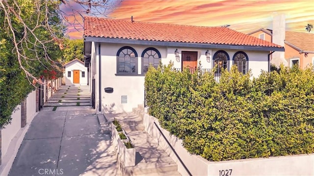 mediterranean / spanish-style home with a tile roof and stucco siding