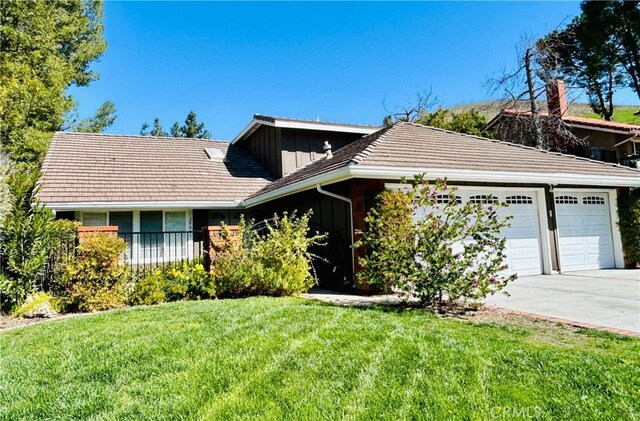 single story home featuring a front lawn, concrete driveway, an attached garage, and a tiled roof