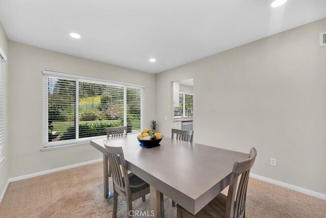 dining space featuring baseboards, light carpet, and recessed lighting
