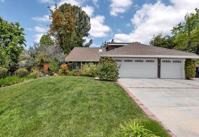 ranch-style house featuring concrete driveway, a tiled roof, an attached garage, and a front yard