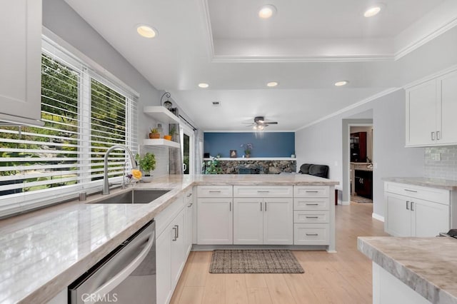 kitchen featuring white cabinets, a sink, dishwasher, a peninsula, and tasteful backsplash