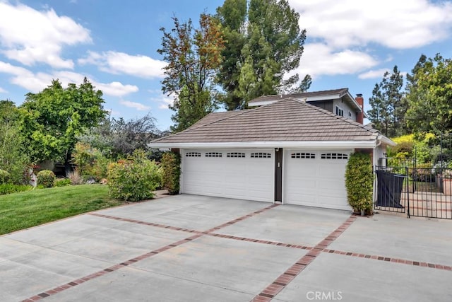 garage featuring fence and driveway