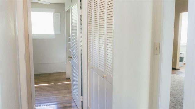 corridor featuring baseboards and wood finished floors