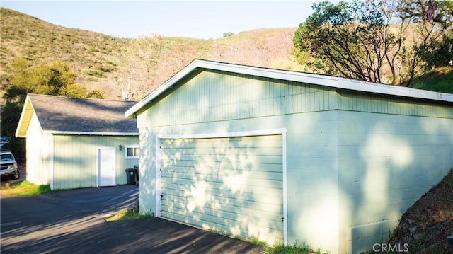 exterior space with a garage, an outdoor structure, and a mountain view