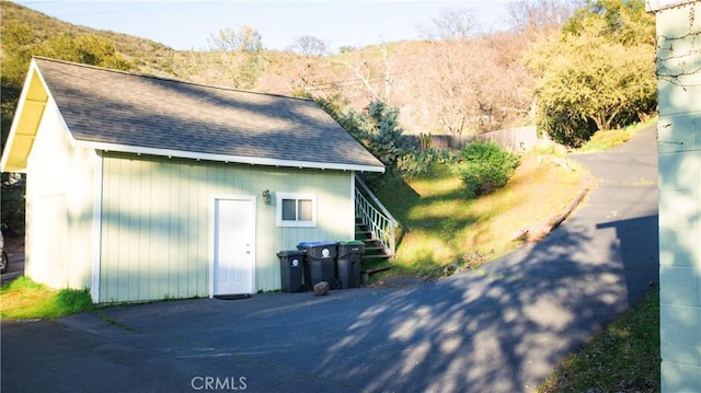 view of side of property featuring roof with shingles