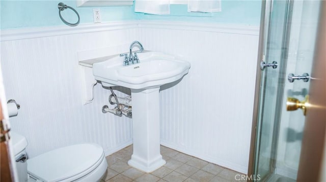 bathroom featuring wainscoting, toilet, and tile patterned floors